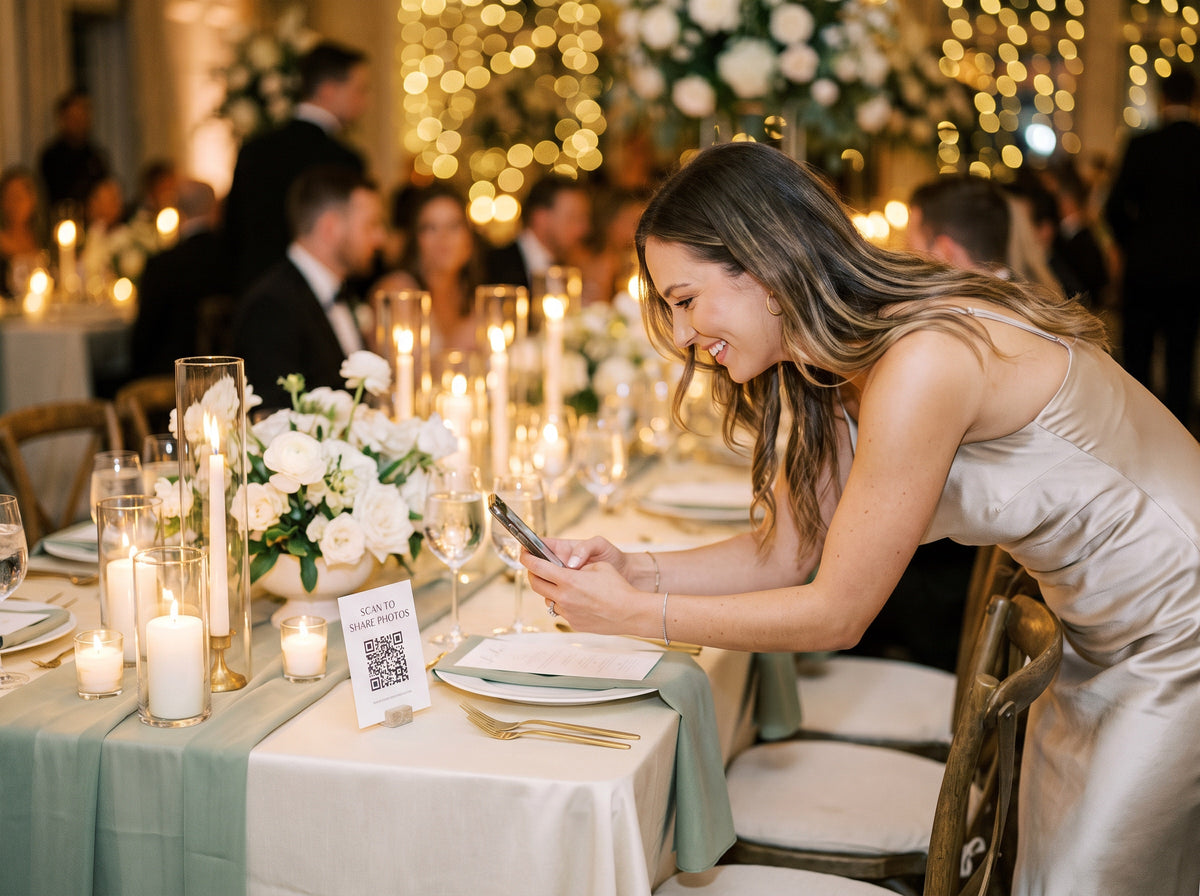 Invitată scanează codul QR de pe masa de nuntă ca să încarce poze în guestbook-ul digital
